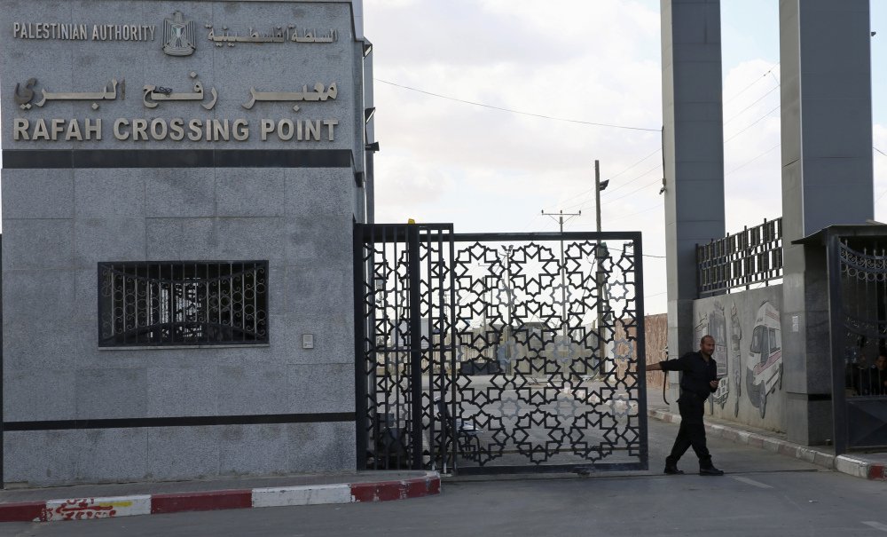 A Hamas security officer closes the main gate of the Rafah border crossing in the Gaza Strip on Tuesday.