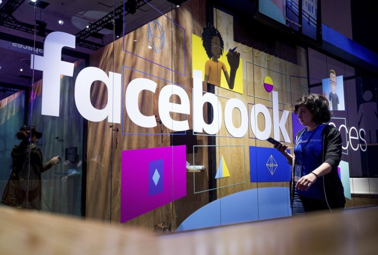 The Facebook name is displayed on a demonstration booth at the annual F8 developer conference in April. The company is doing more monitoring for harmful content.