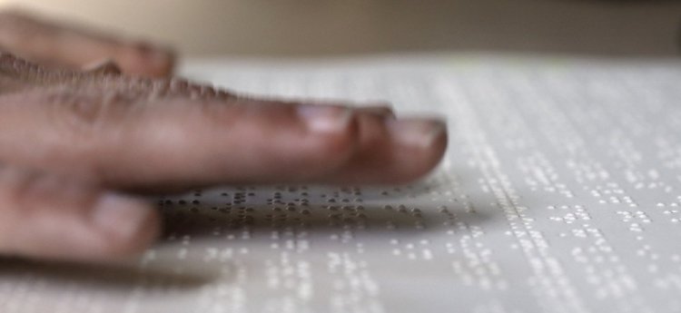 Proofreader Georgie Sydnor runs her fingers over Braille at the National Braille Press in Boston. The organization has been a leading force for Braille literacy in the U.S. since its founding as a weekly newspaper for the blind in 1927.