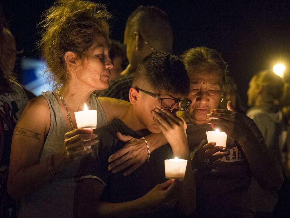 Mona Rodriguez holds her 12-year-old son, J. Anthony Hernandez, during a candlelight vigil for the victims of a fatal shooting Sunday in Sutherland Springs, Texas. 