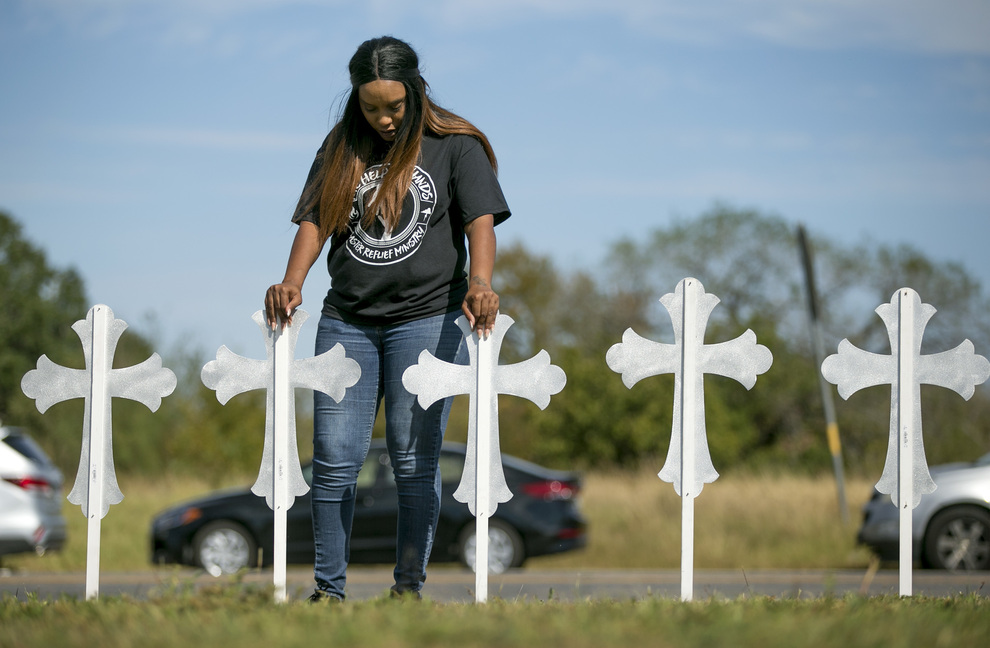 Sheree Rumph, of San Antonio, prays over two of the 26 crosses erected in memory of the 26 people killed in a shooting in Sutherland Springs, Texas, on Monday. The shooting took place during a Sunday service at the Sutherland Springs First Baptist Church. 