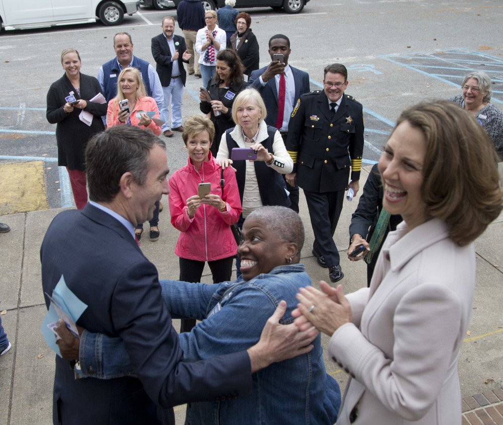 Democratic gubernatorial candidate Lt. Gov. Ralph Northam, left, gets a hug from a supporter as his wife, Pam, stands at right after voting in Norfolk, Va., on Tuesday. Northam won.