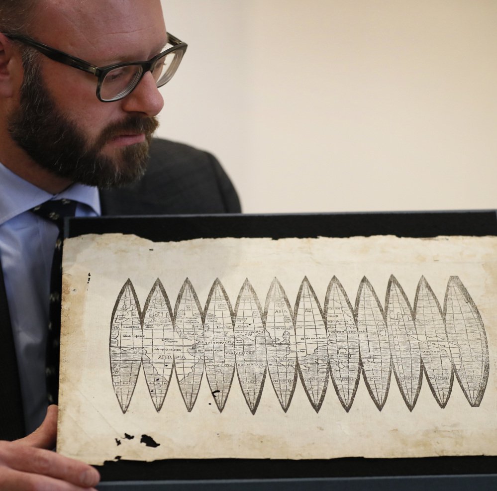 Cartographer Martin Waldseemueller displays a 510-year-old map dubbed "America's birth certificate" at Christie's auction rooms in London on Tuesday.