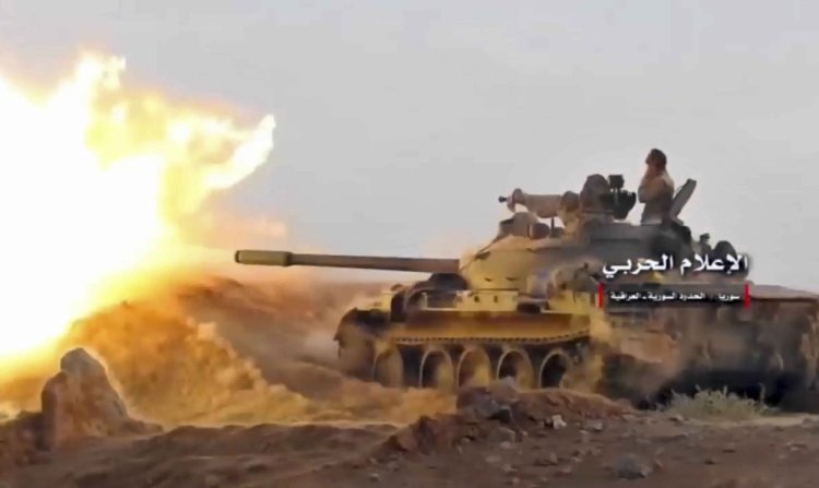 The frame from a video by the government-controlled Syrian Central Military Media shows a tank firing on militants' positions on the Iraq-Syria border. 