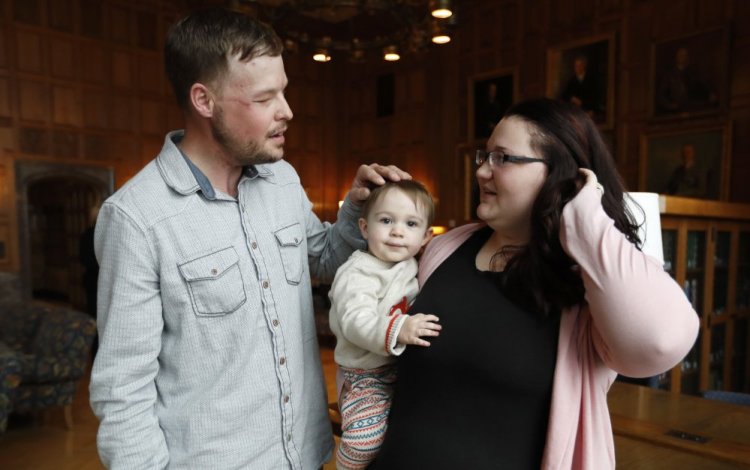 Lilly Ross, right, holds her 17-month-old son Leonard as she talks with face transplant recipient Andy Sandness, left, after their first meeting at the Mayo Clinic.