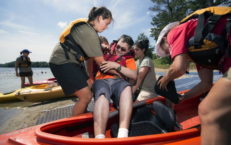 Johnny Nguyen is lowered into a tandem kayak by staff members of Massachusetts' Universal Access Program during an event at Cochituate State Park in Natick, Mass., last summer. The commonwealth offers adaptive recreational opportunities to people with physical disabilities and serves as a model for other states.