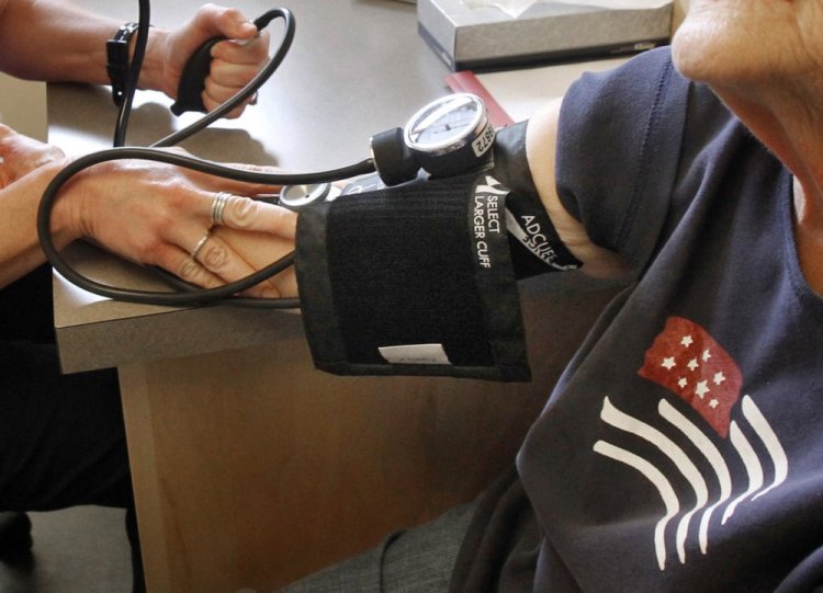 A patient has her blood pressure checked by a registered nurse in Plainfield, Vermont. New medical guidelines announced Monday lower the threshold for high blood pressure, adding 30 million Americans to those who have the condition.