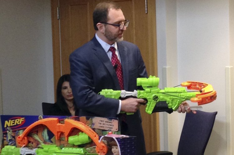 James Swartz, director of World Against Toys Causing Harm, or WATCH, displays Nerf's "Zombie Strike" crossbow during a news conference Tuesday in Boston, where the child-safety group released its annual holiday list of the 10 most hazardous toys.