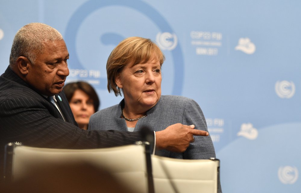 Fiji prime minister and COP president Frank Bainimarama, left, talks to German Chancellor Angela Merkel during the 23rd Conference of the Parties (COP) climate talks in Bonn, Germany, Wednesday.
