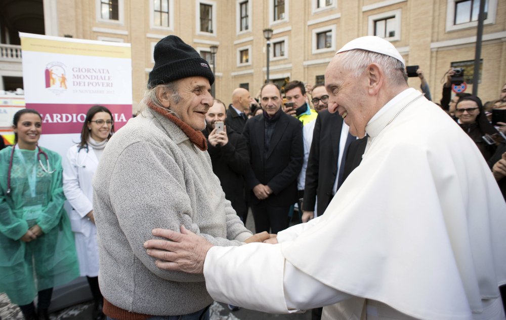 L'Osservatore Romano via AP
Pope Francis greets an unidentified man during a surprise visit to a small facility near St. Peter's Square where doctors on a volunteer basis give poor people medical exams, Thursday. Francis decried that, increasingly, only the privileged can afford sophisticated medical treatments and urged lawmakers to ensure that health care laws protect the "common good."