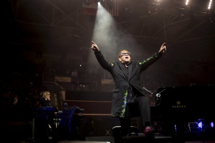 Elton John leaves the piano and gestures to the excited crowd during his first song Friday at the Cross Insurance Arena.