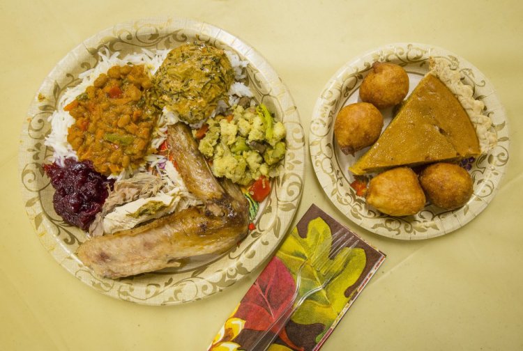 For many Mainers, Thanksgiving is a chance to blend cultures and cuisines. On the small plate are pumpkin pie and African doughnuts. On the large plate are, clockwise from top, Congolese fumbwa, stuffing, traditional Thanksgiving turkey, cranberry sauce and South African chakalaka.