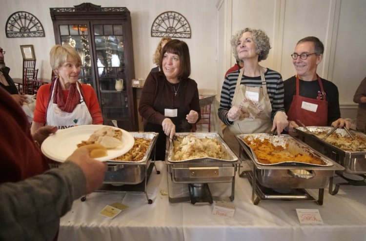 Volunteer Lisa Reardon, second from left, serves up mashed potatoes to an attendee at the Portland Club on Thursday. Joining her on the serving line are Gayle Duncan, left, and Lynne and Rick Gammon, right. About 50 volunteers helped to serve about 250 meals.