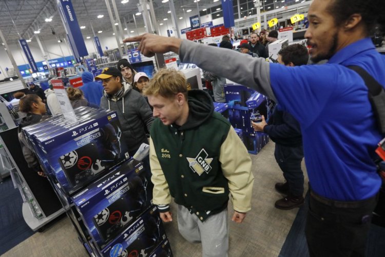Shoppers rush into Best Buy as the doors open early Friday morning in Dartmouth, Mass.