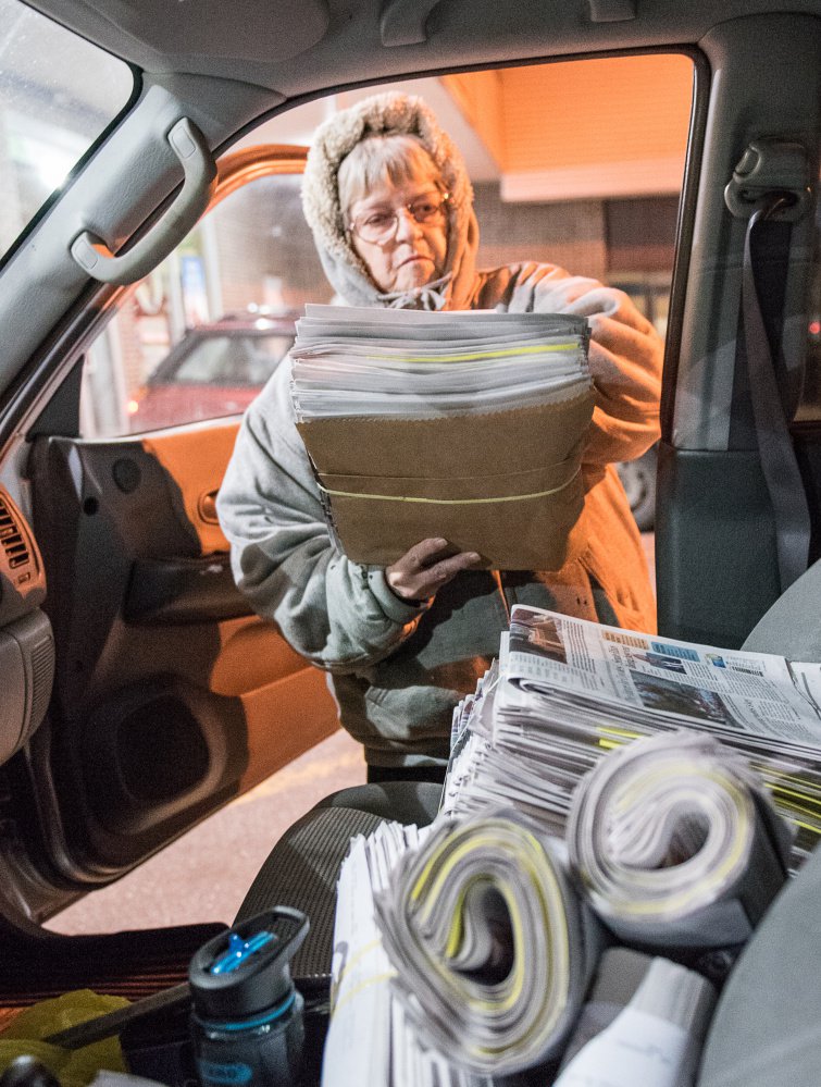 Kay Brackley loads bundles of newspapers she picked up in Farmington on a Saturday. "You do it night after night and you know what lights are on at houses and what cars are in the yard," she said. "You get to know your customers."