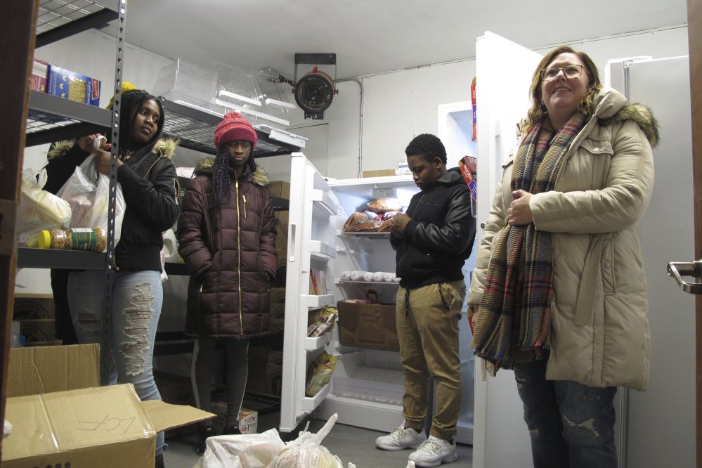 Volunteers at a student-run food pantry, from left, Shinna Sackie, Isa Badje, Joel Gama and Brooke Badjie, help load up bags of groceries on Nov. 16 to be delivered to needy people in Fargo, N.D. 