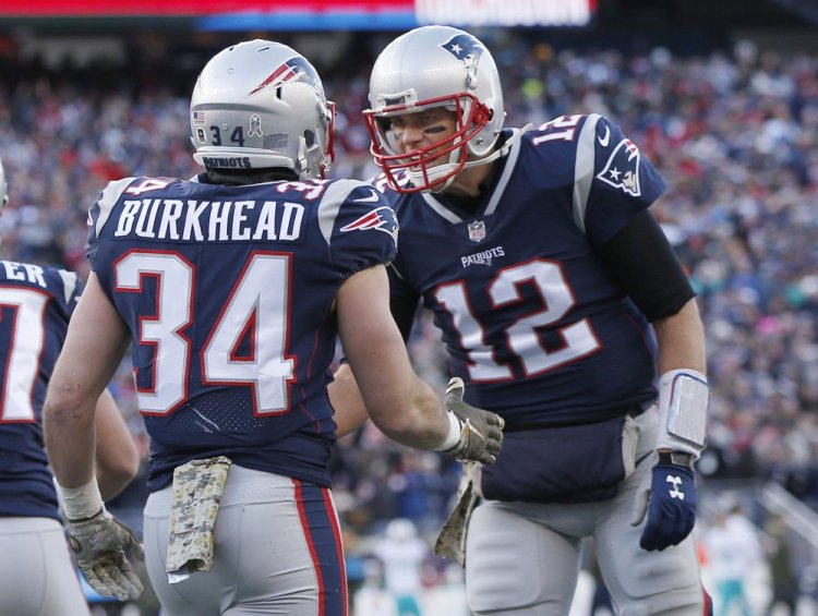 New England Patriots quarterback Tom Brady, right, celebrates his touchdown pass to running back Rex Burkhead during the first half of the Patriots' 35-17 win over the Miami Dolphins on Sunday in Foxborough, Massachusetts.
