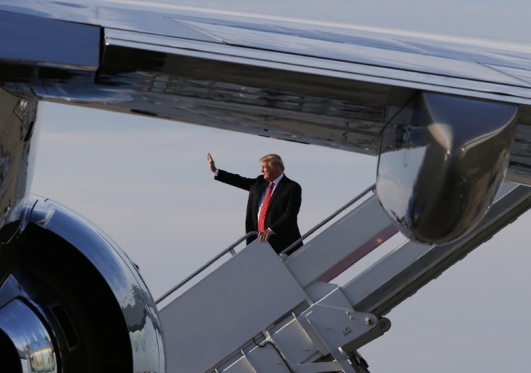 President Trump waves as he boards Air Force One in Palm Beach on Sunday. White House officials say the president will not campaign for Alabama senate hopeful Roy Moore.