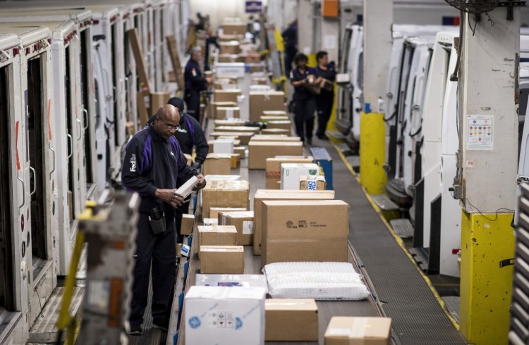 Employees sort packages for delivery at the FedEx Corp. shipping center in Chicago on Monday. C. Britt Beemer of America's Research Group said computers and smaller electronics were the top sellers, followed by clothing.
