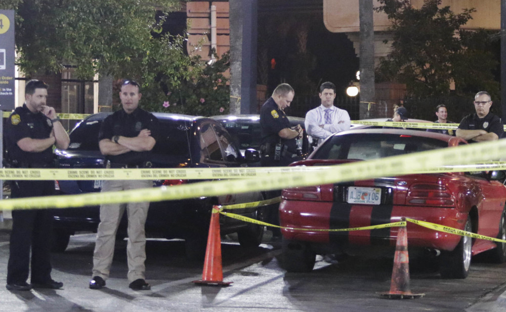 Officers process possible evidence and a red sports car at a McDonalds in Ybor City in Tampa, Fla., Tuesday, after the arrest of a suspect in a series of fatal shootings.