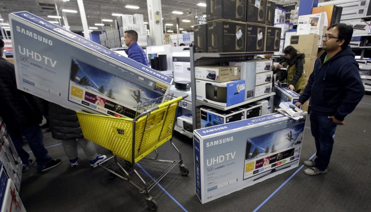 People wait to pay for televisions as they shop a sale at a Best Buy store in Overland Park, Kan. For the five-day period that ended Monday, shoppers seemed to spend more in 2017 than a year earlier.