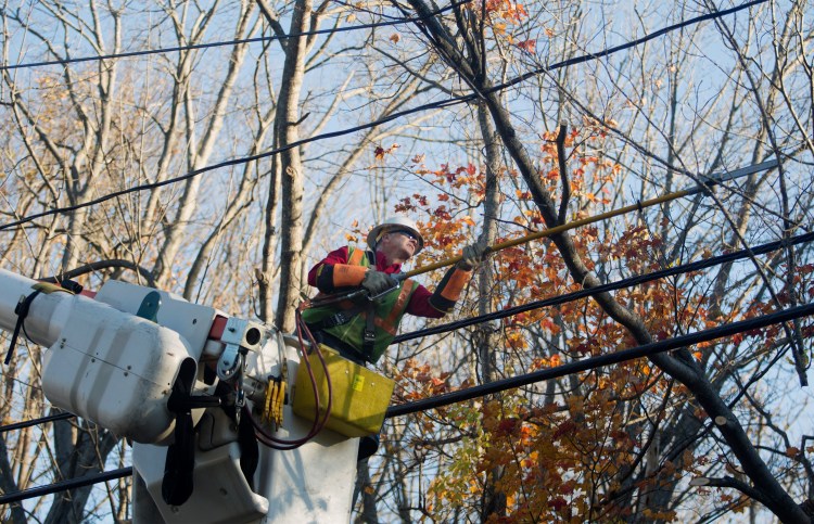 CMP lineman Mike Ross cuts a large tree branch down from a power line on Mitchell Road in South Portland on Oct. 31. A damaging late-October windstorm knocked out power to nearly a half-million CMP customers.