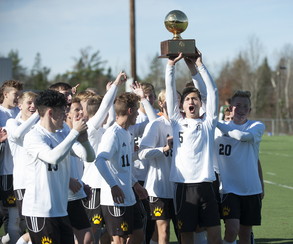 The Maranacook boys soccer team celebrates with the Gold Ball after it defeated Fort Kent 1-0 in the Class C state championship game Saturday morning at Hampden Academy.