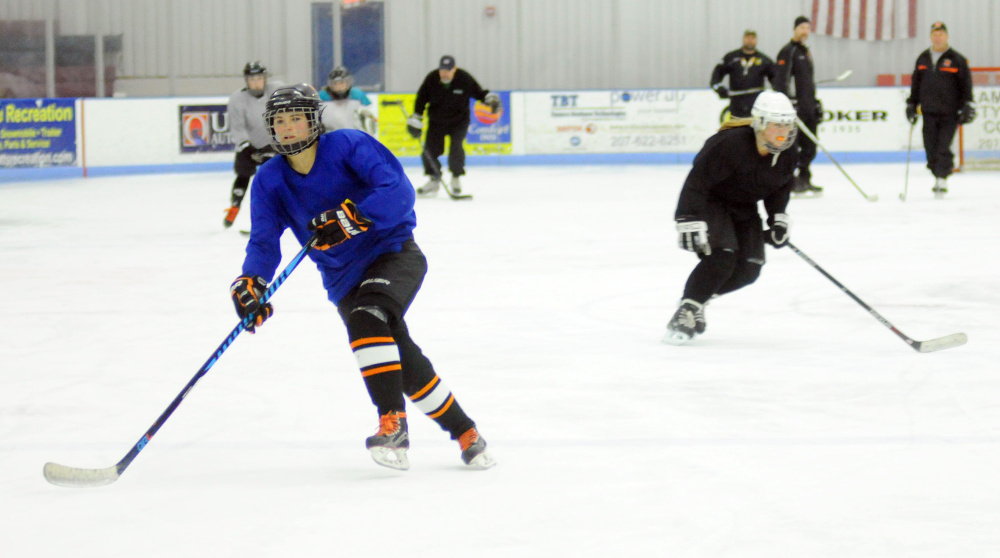 Winslow/Gardiner hockey player Kathryn Bailey, left, skates  during a drill Tuesday night at the Camden National Bank Ice Vault in Hallowell.