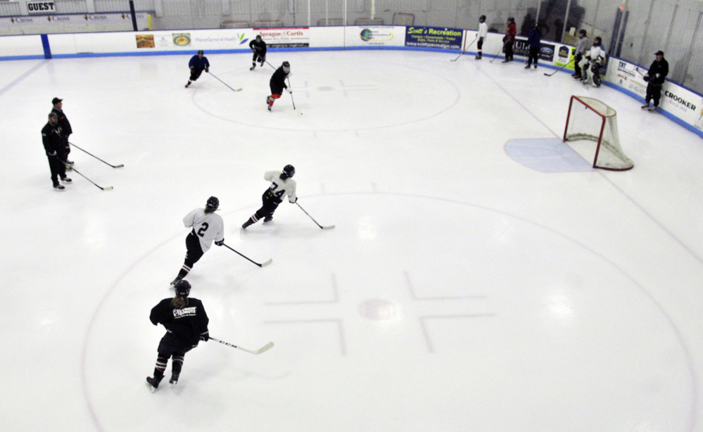 Winslow/Gardiner girls hockey players loop around the faceoff circles during a drill Tuesday night at the Camden National Bank Ice Vault in Hallowell.