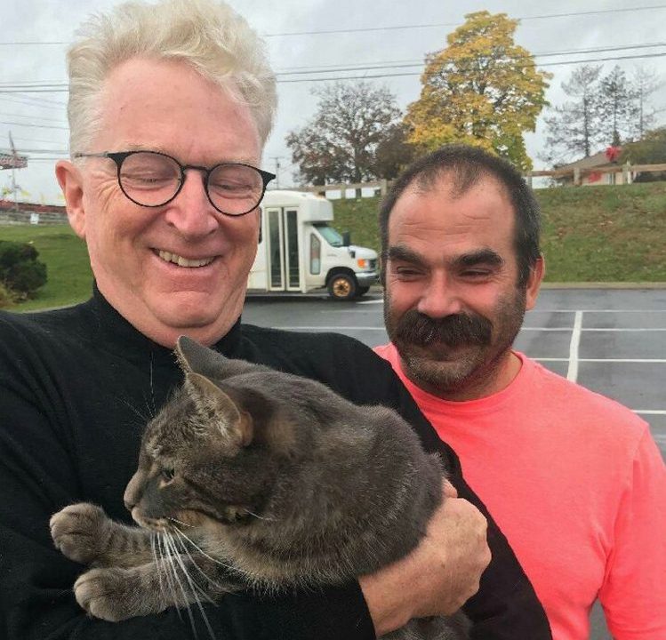 George Lichte, of Kennebunkport, left, holds his cat, Romeo, as Kevin Taft, of Solon, who found the cat in Unity after it had been missing for a year, watches.