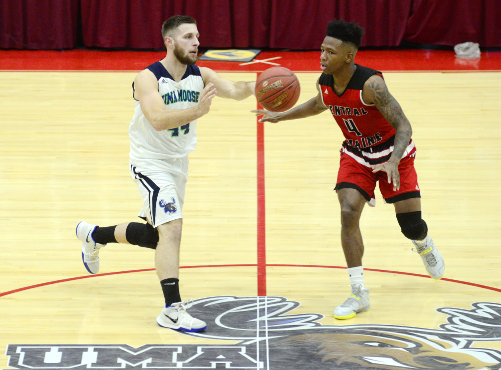 University of Maine at Augusta guard Jordan Holmes, of Oakland, left, passes  in front of Central Maine Community College defender Akeem Laurie during a game Wednesday at the Augusta Civic Center.