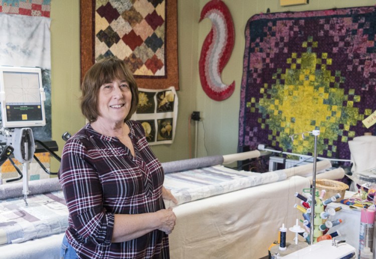 Lynn Irish, owner of WhipperSnappers Quilt Studio in Hallowell stands next to a long arm quilting machine on Saturday. She is preparing to move her shop at 109 Water St. to a the former location of Buddy's Diner. Irish says her new shop will double in size.