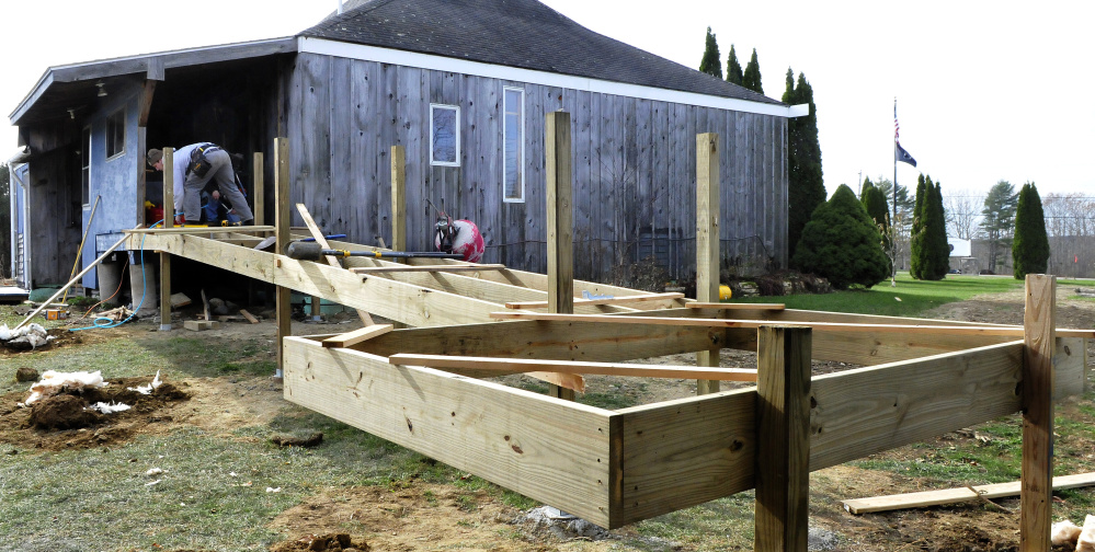 Workers erect the new wheelchair ramp at the Palermo Community Center on Sunday.