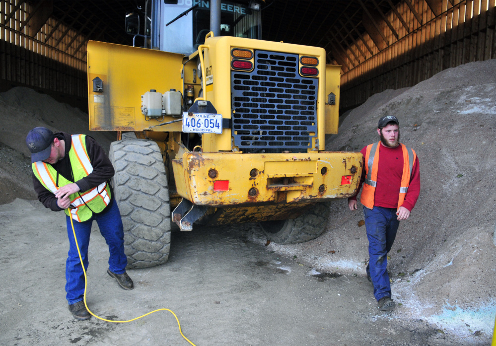 Manny Proctor cleans the sand out of the extension cord before plugging it into the block heater on front end loader that Justin Miller just moved into the salt shed on Thursday at the John Charest Public Works Facility in Augusta. The men recently got their Class B Commercial Drivers Licenses and will be driving plow trucks for the city this winter.