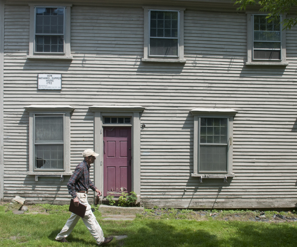 Hallowell city historian Sam Webber walks past the Dummer House during an interview in June. City officials on Monday discussed a proposal to move the historic home.
