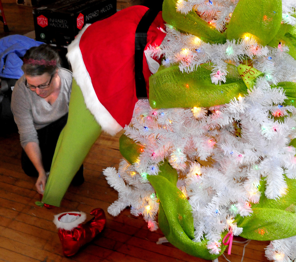 Tammy Richards places The Grinch on Tuesday inside a Christmas tree sponsored by Choice Investments for the upcoming Sukeforth Family Festival of Trees at the Hathaway Creative Center in Waterville.