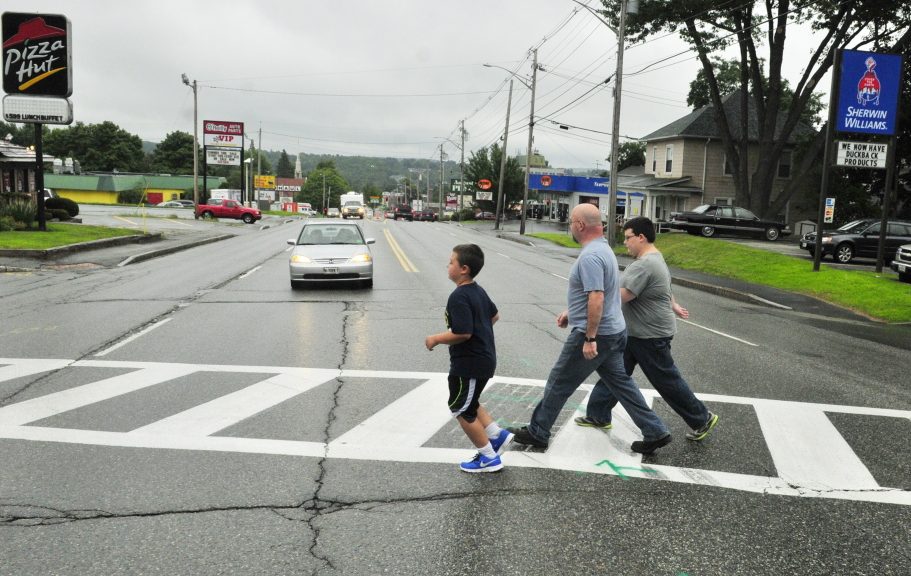 Jason Wyman, center, and his sons, Keygan, 10, left, and Ayden, 11, cross Western Avenue in Augusta in 2014 in a crosswalk where the avenue intersects with Florence and Cushman streets. A forum held Wednesday in Augusta sought comments from pedestrians and others about ways to improve safety in the city.
