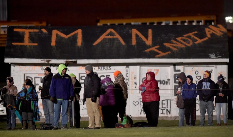Fans stand along the sideline of the Skowhegan Area High School football game against Lawrence High School on Friday in Skowhegan. A group of local professionals is expected to deliver a letter to the School Administrative District 54 board this evening to call for discontinuing the use of the term "Indians" for the school's sports teams.