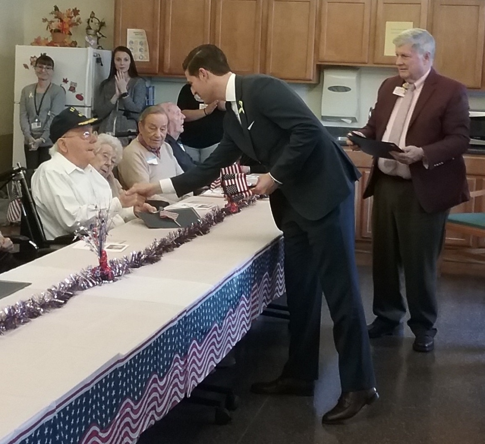 Roland Michaud, veteran of the Navy who served in WWII, shakes hands with Waterville Mayor Nick Isgro. On his left are, Yvette Mitchell, Paul Mitchell, Navy veteran, Russ Perham Army and Airforce veteran Inland Hospital president John Dalton, right, hands out certificates of recognition.