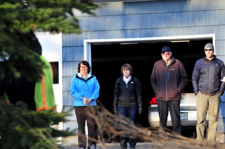Joe Lemieux, second from right, watches as Waterville Public Works employees cut down a spruce tree Monday at his home in Fairfield. Lemieux donated the tree to the city of Waterville for Christmas. Also watching are nieces Patricia Hildreth, left, and Bernadette LaCroix and Parks and Recreation Director Matt Skehan.