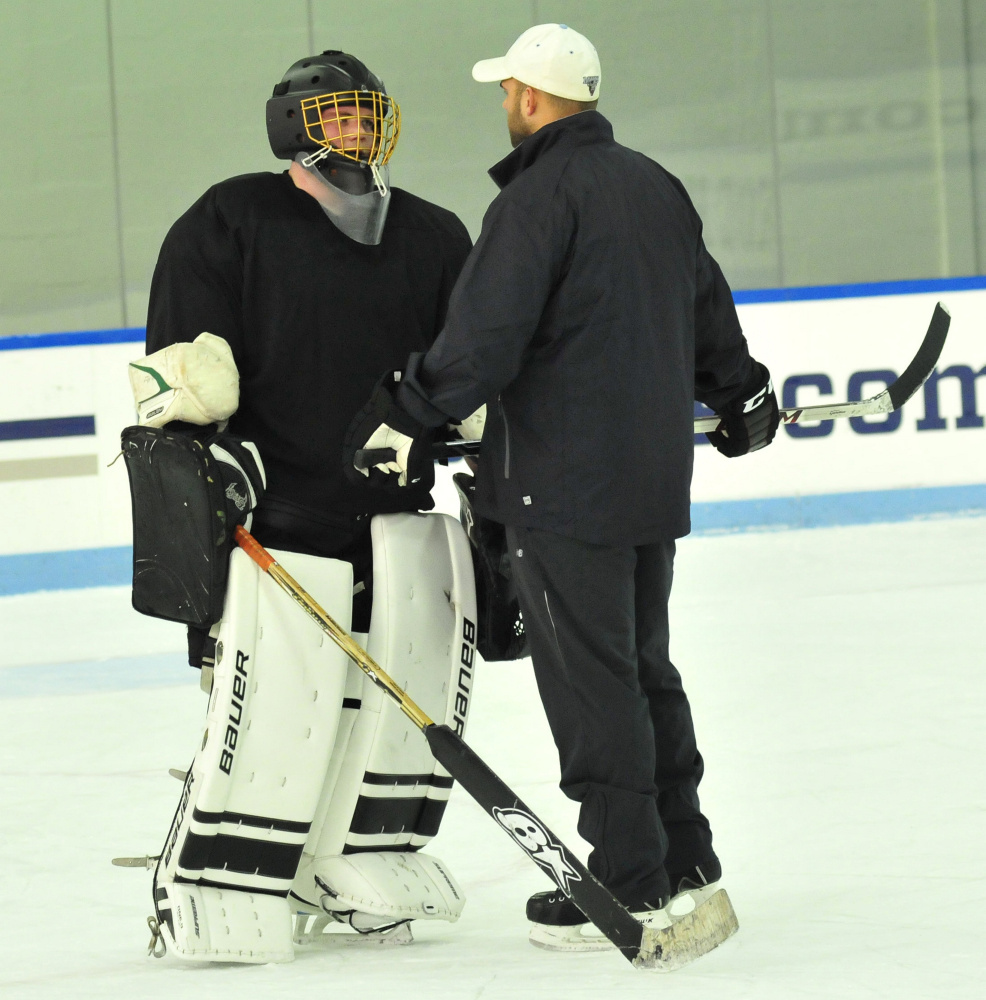 Kennebec RiverHawks coach Jon Hart talks to goalie Ben Grenier during practice Monday at Colby College.