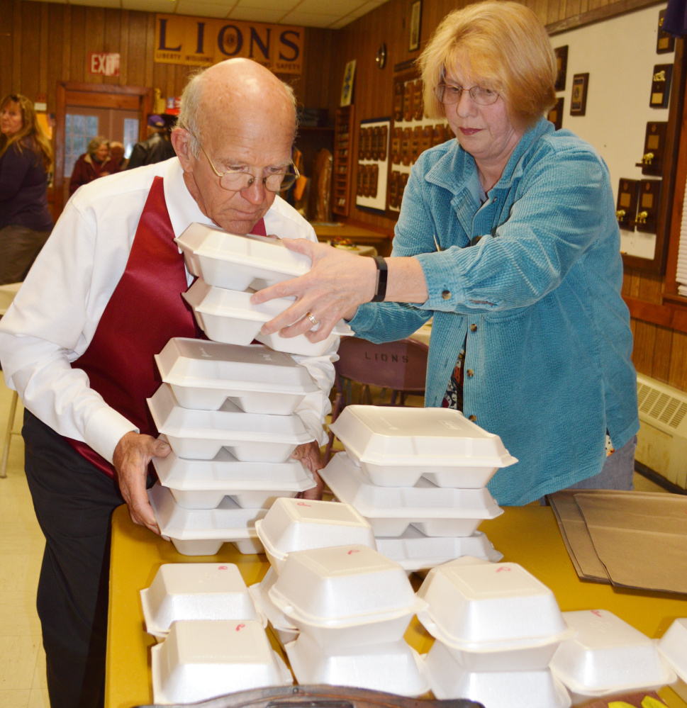 Tim Chase, left, and Carol Jones, help with the Thanksgiving meal preparation.