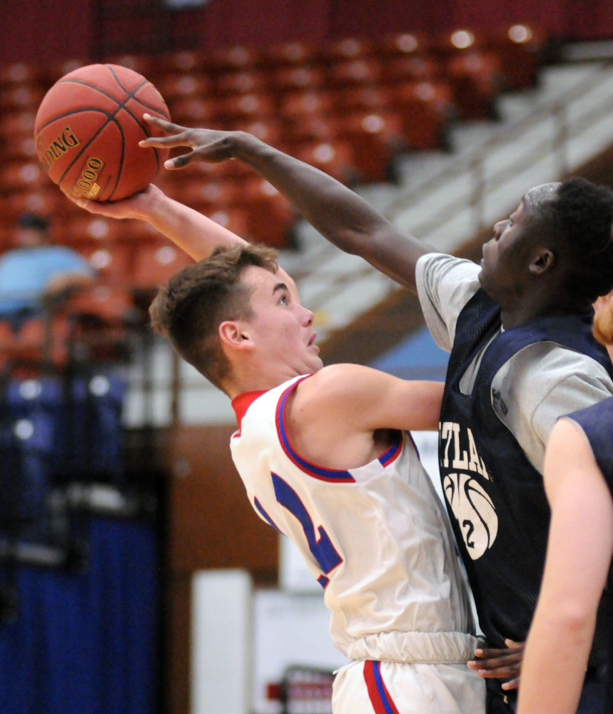 Messalonskee's Tucker Charles, left, tries shoot over Portland's Emmanuel Yugu on Friday at the Augusta Civic Center.