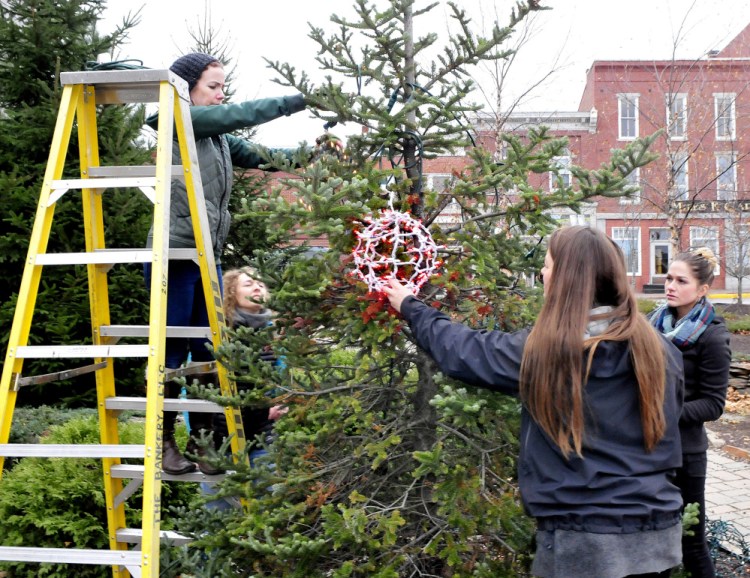 Main Street Skowhegan volunteers and board member Darcy Spooner, second from left, string hand-made balls of Christmas lights on trees Wednesday in the park in downtown Skowhegan for the upcoming 25th annual Holiday Stroll. Volunteers are, from left, Devin MacMichael, Spooner, Mary Haley and Kylie Damon.