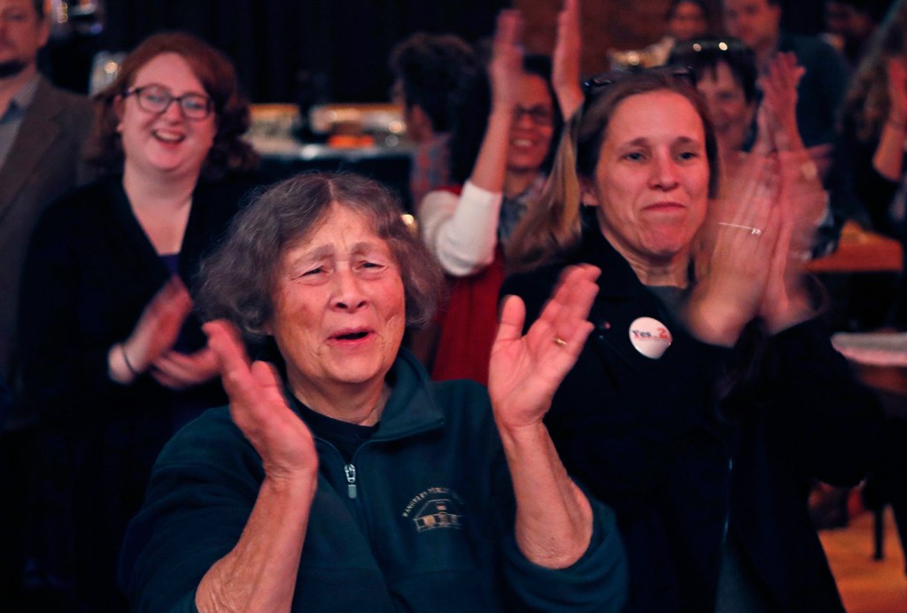 Chris Hastedt, left, and Robyn Merrill cheer during an announcement while awaiting results at the Mainers for Health Care election night party on Tuesday in Portland. Voters decided to join 31 other states and expand Medicaid under former President Obama's Affordable Care Act. 