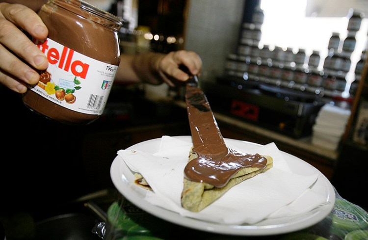 The bartender spreads Nutella on a crepe in a creperie in Rome in 2010. 