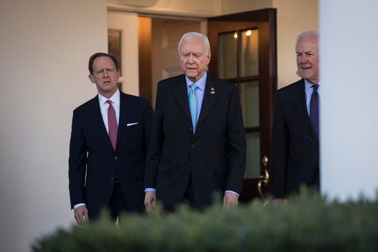 Senate Finance Committee Chairman Orrin Hatch, R-Utah, center, and Sens. John Cornyn, R-Texas, right, and Patrick Toomey, R-Pa., walk from the West Wing to speak to reporters after a meeting with President Trump on Monday.