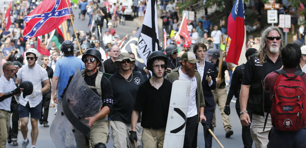 White nationalist demonstrators walk through town after their rally was declared illegal near Lee Park in Charlottesville, Va., last August.