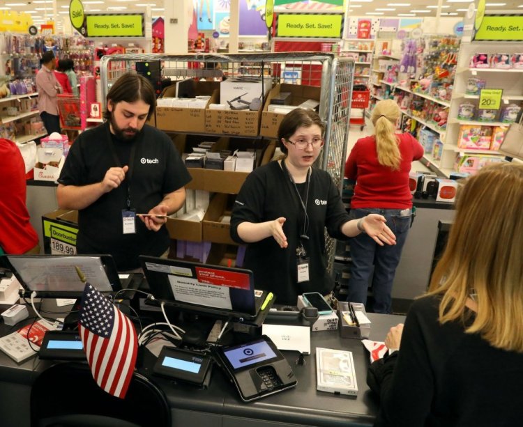 Brad Garrett, left, and Angela Johannsen help customers in the tech department of Target in Ballwin, Mo., on Tuesday, as the service sector reported its 95th month of consecutive growth.