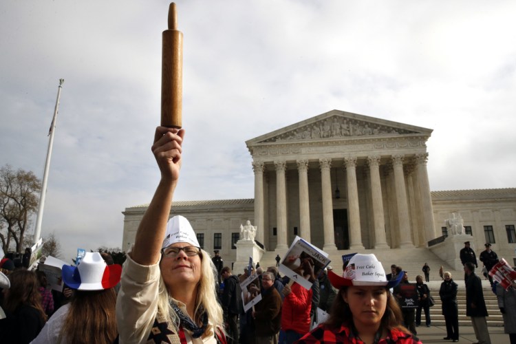 A demonstrator outside the U.S. Supreme Court in December 2017 holds up a rolling pin in support of baker Jack Phillips during arguments in the case of Masterpiece Cakeshop vs. Colorado Civil Rights Commission, also known as the wedding cake case.